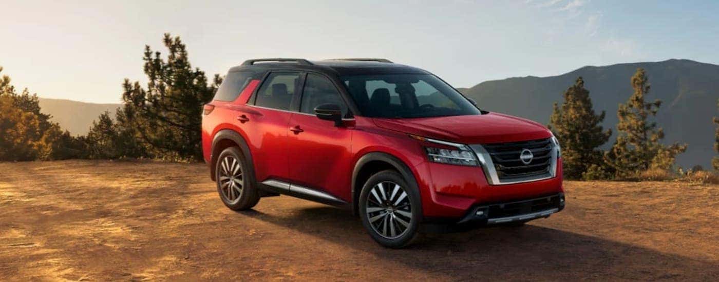 A red 2021 Nissan Pathfinder is shown from the front at an angle.