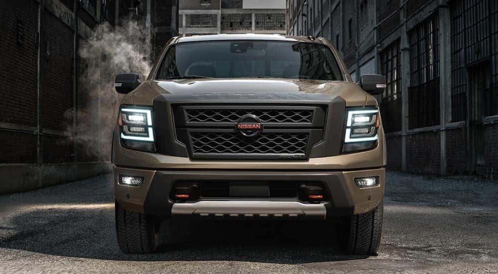 A tan 2021 Nissan Titan Pro4x parked in an industrial alleyway.
