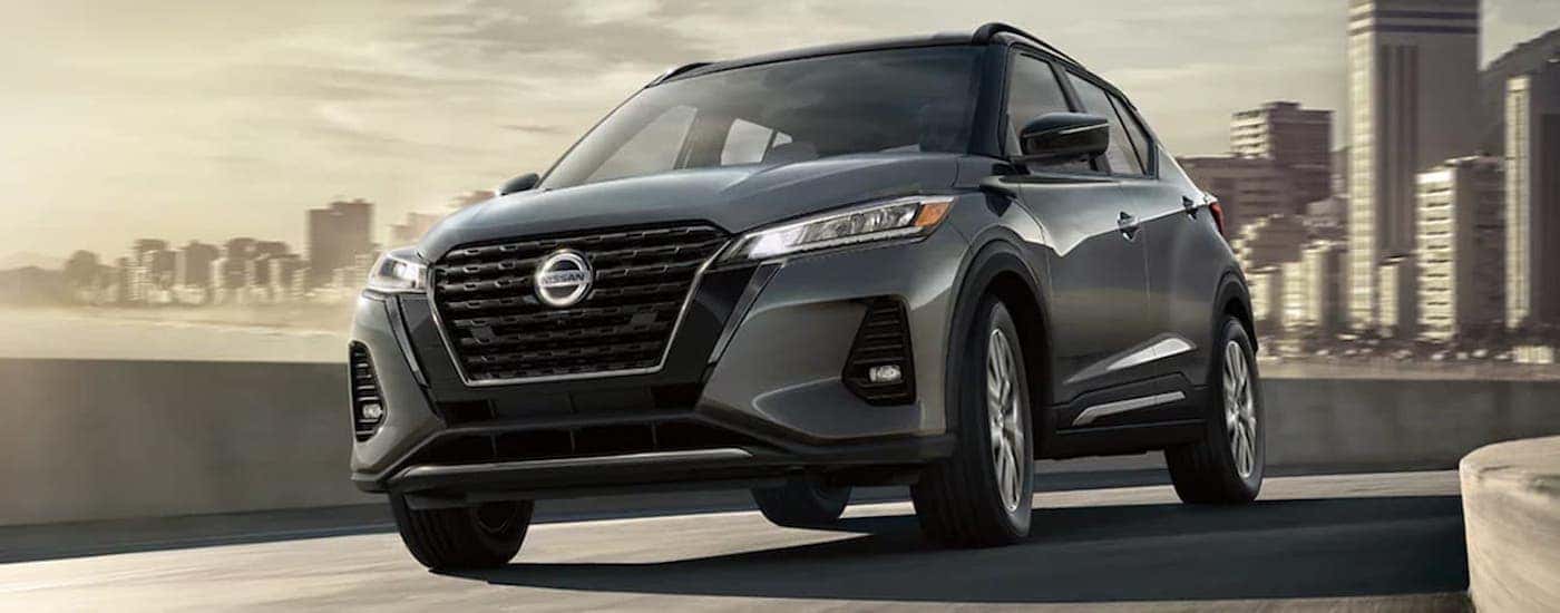 A grey 2021 Nissan Kicks is shown rounding a corner.