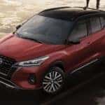 Aerial view of a red 2022 Nissan Kicks parked on a wet and sandy beach