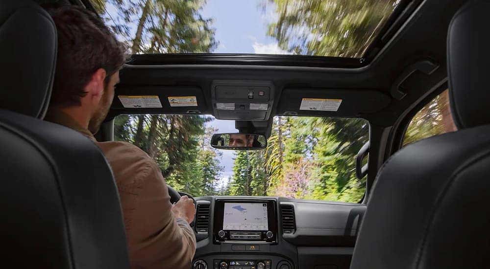 A man drives a 2022 Nissan Frontier PRO-4x through the woods