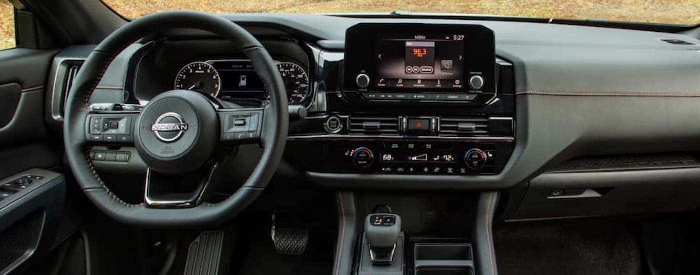 The black interior of a 2023 Nissan Pathfinder Rock Creek is shown from the drivers seat.