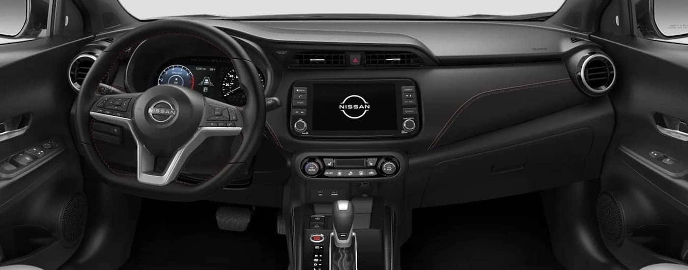 The black dash of a 2023 Nissan Kicks is shown from above the center console after leaving a dealer that has a Nissan Kicks for sale.