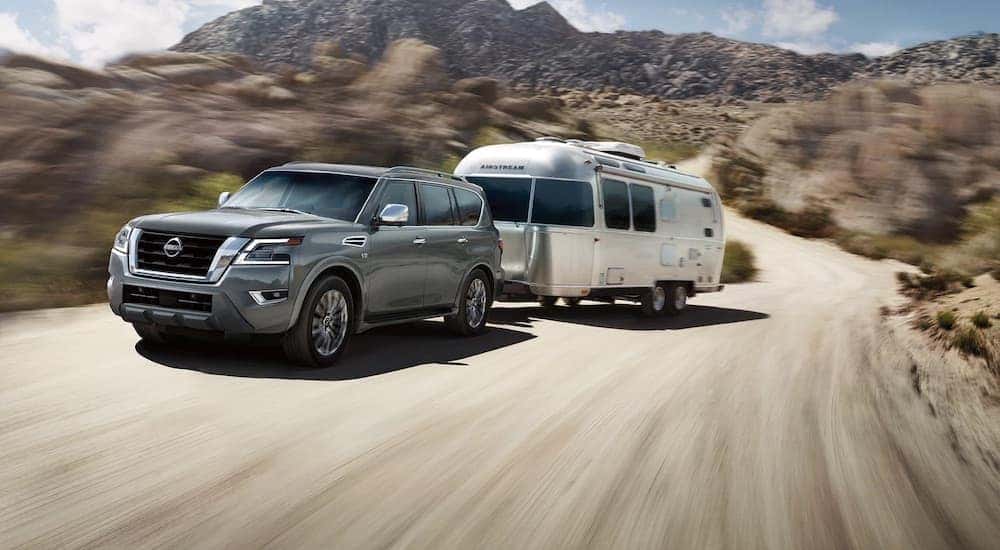 A grey 2023 Nissan Armada is shown from the front at an angle while towing an airstream camper.