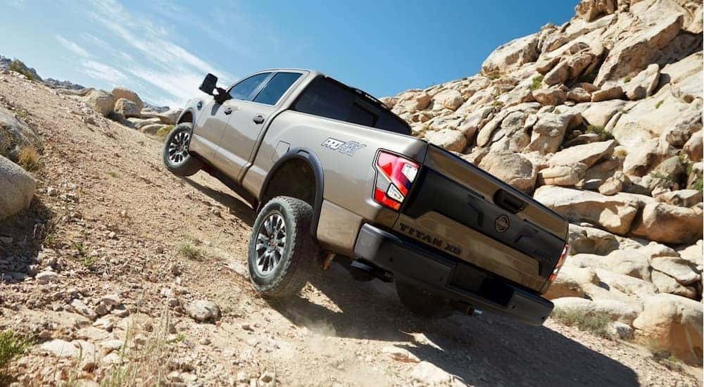 A tan 2024 Nissan Titan PRO-4X is shown off-roading.
