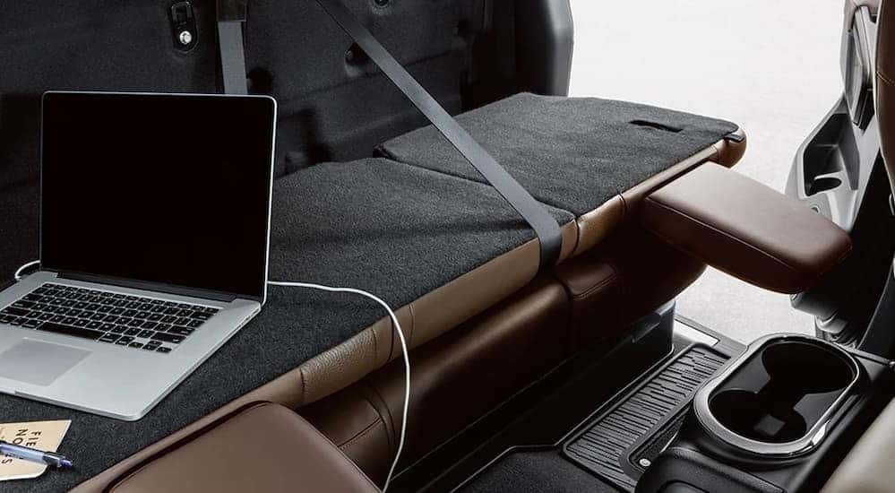The black and brown rear seating and foldable workbench is shown in a 2024 Nissan Titan.