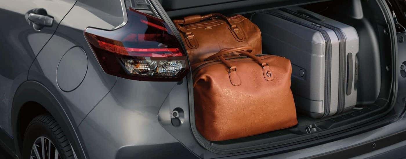 Luggage is shown in the trunk of a grey 2023 Nissan Kicks.