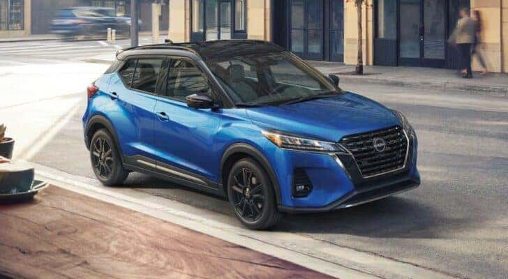 A blue 2023 Nissan Kicks for sale near Columbia is shown on a city street.