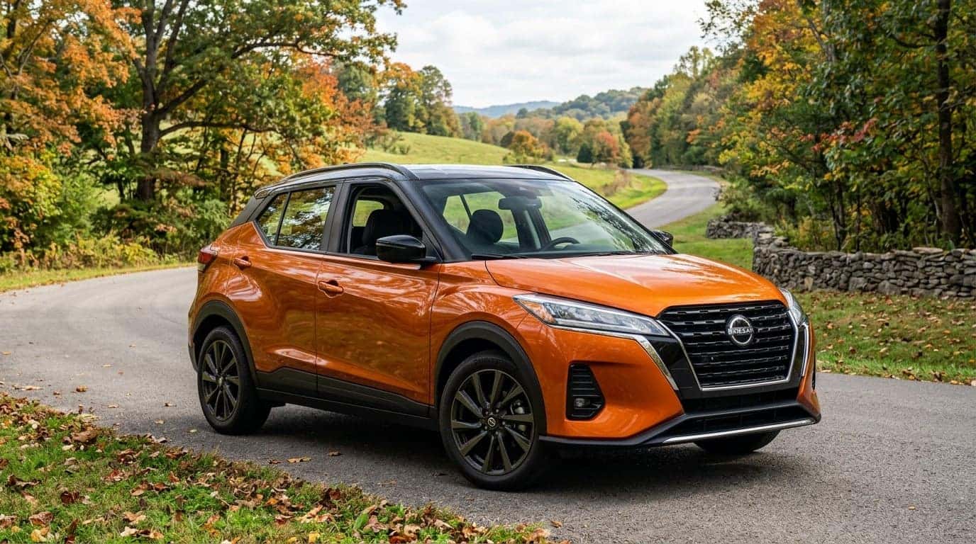 A high-quality editorial photograph of a 2025 Nissan Kicks parked along a scenic paved suburban road in Middle Tennessee during early autumn, framed by gently rolling green hills and turning oak trees, three-quarter front view capturing the modern compact crossover design, crisp natural daylight casting soft reflections on the metallic painted body, driver door slightly open revealing a sleek dark interior with a modern digital dashboard, quiet rural suburban environment, realistic colors, rich detail. No text, no logos other than natural vehicle badging, no identifiable faces. (Representative image for illustration purposes only. Actual vehicle may vary based on trim and configuration.)