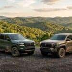 2025 Nissan Frontier PRO-4X and Toyota Tacoma TRD Off-Road parked side by side on a Tennessee overlook