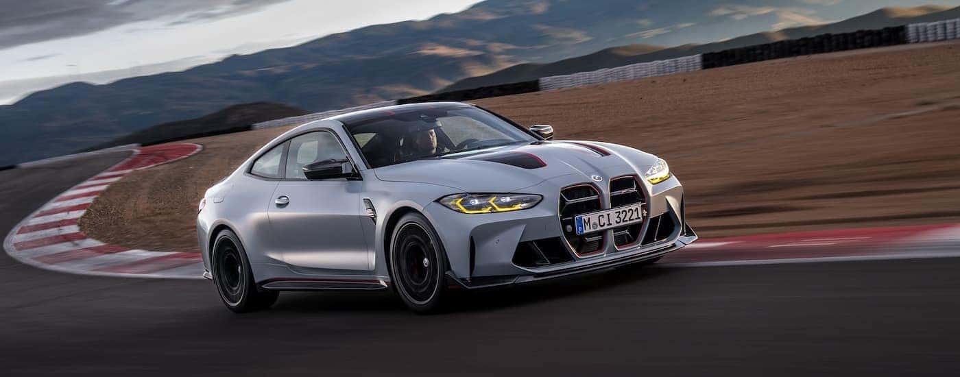 A grey 2-24 BMW M4 CSL is shown from the front at an angle,