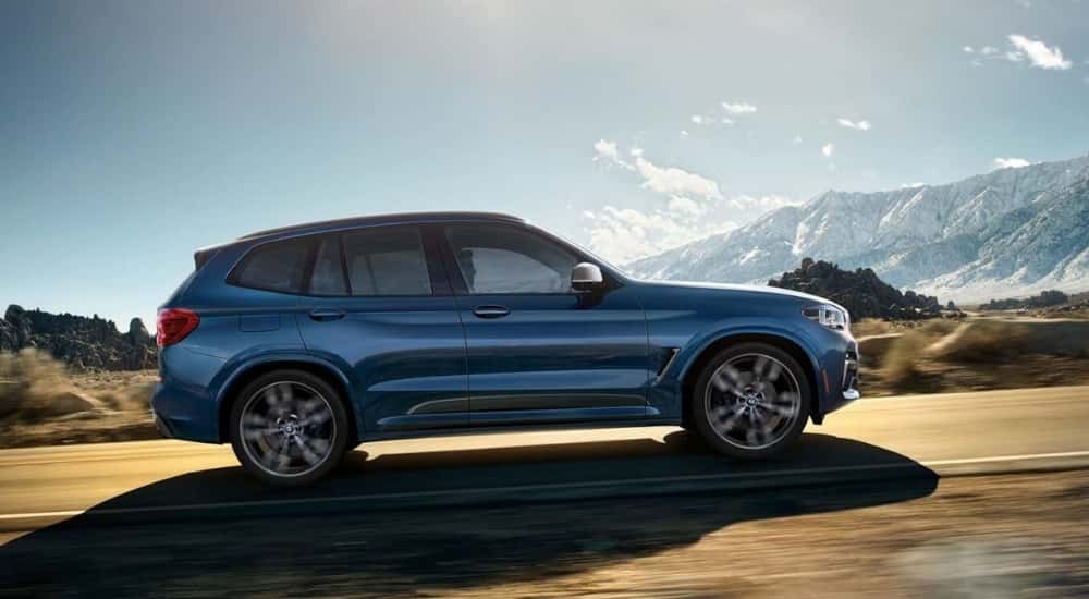 A blue 2018 BMW X3 is shown driving to check out a used BMW for sale.