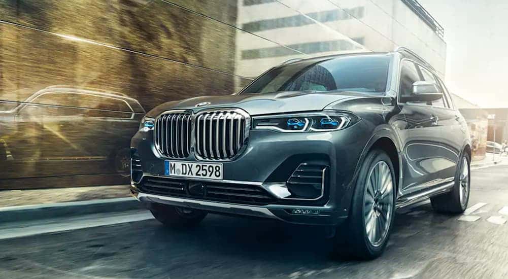 A grey 2020 BMW X7 driving through a city.