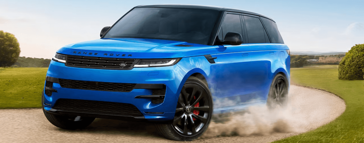 A blue 2025 Range Rover Sport driving on sand