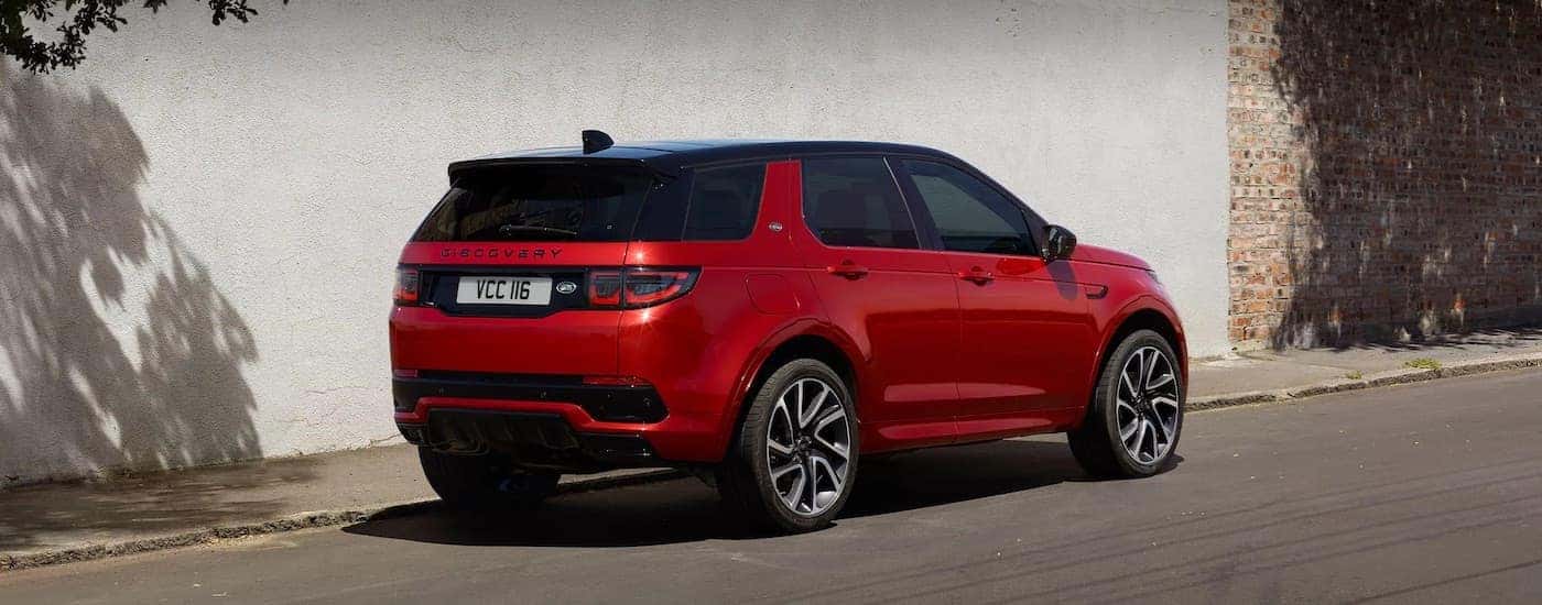 A red 2025 Land Rover Discovery from the rear at an angle.