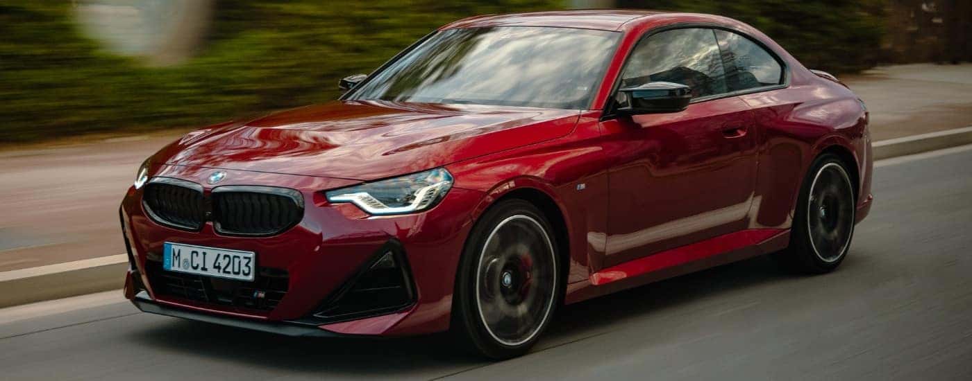 A red 2025 BMW M240i from the front at an angle.