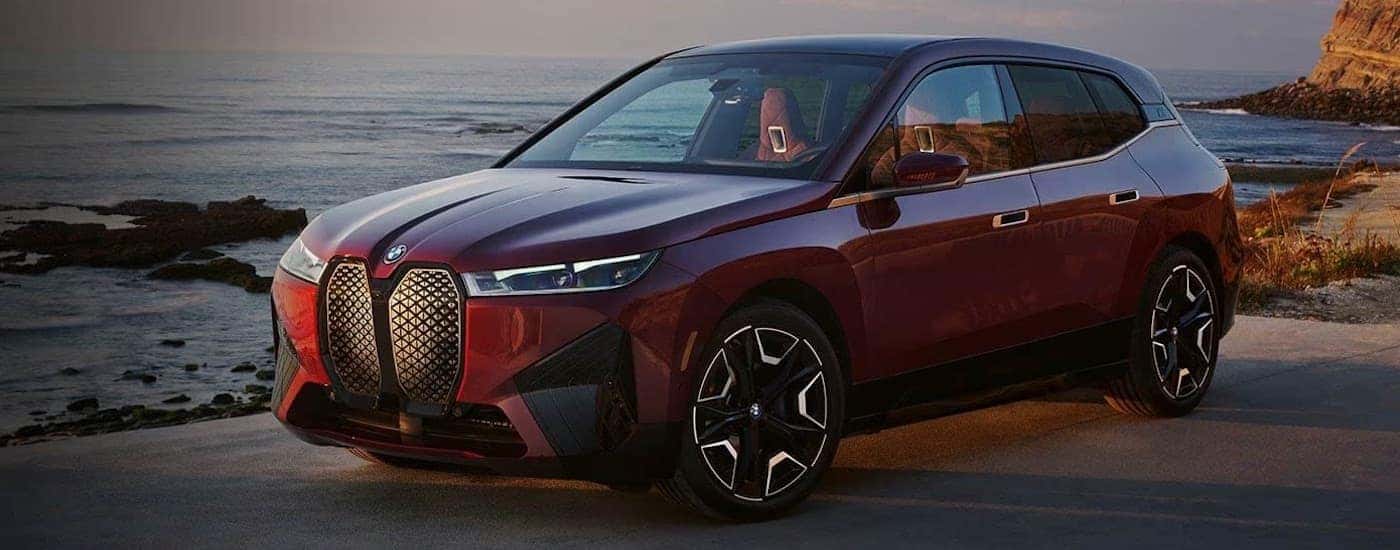 A red 2025 BMW iX from the side after leaving a BMW dealer near Lincoln.