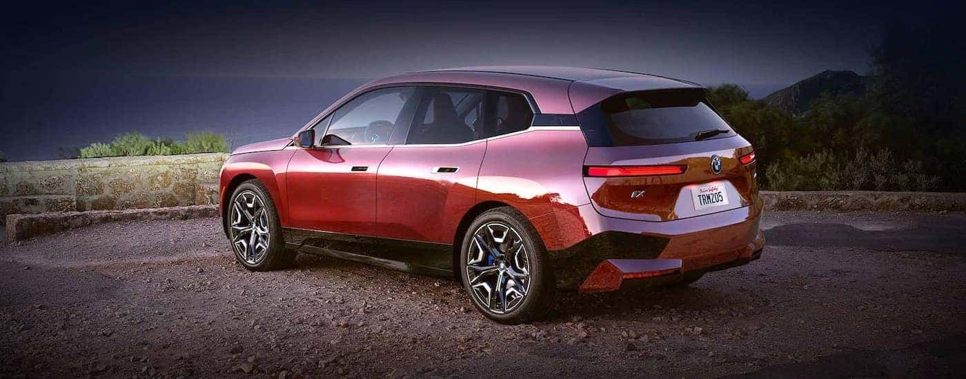 A red 2025 BMW iX from the side.