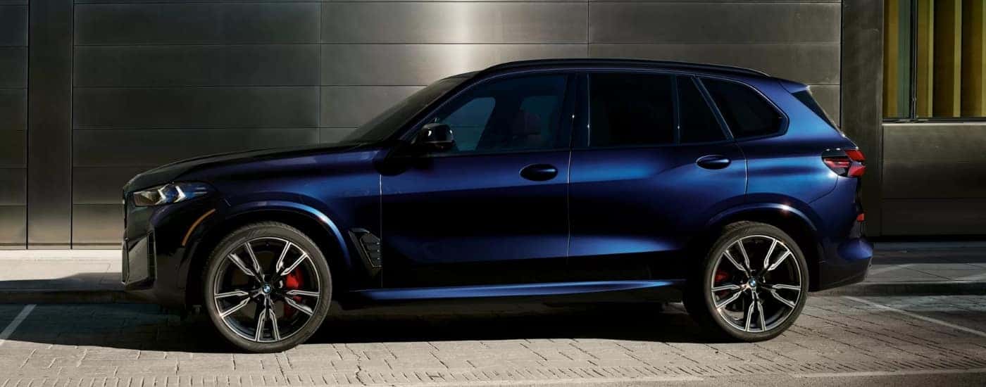 A blue 2026 BMW X5 M60i in a parking space.
