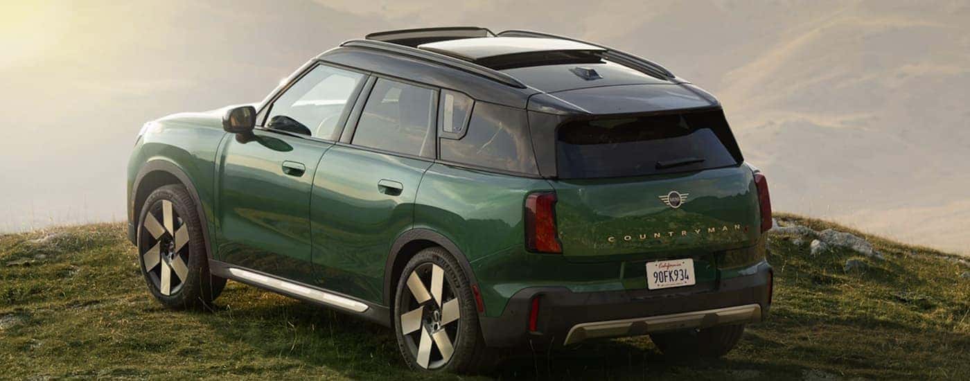 A green 2025 MINI Countryman parked off-road on grass