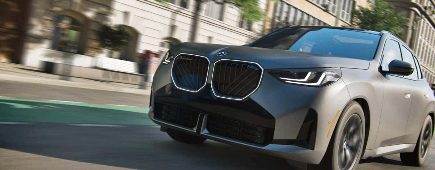 A gray 2026 BMW X3 driving on a city street