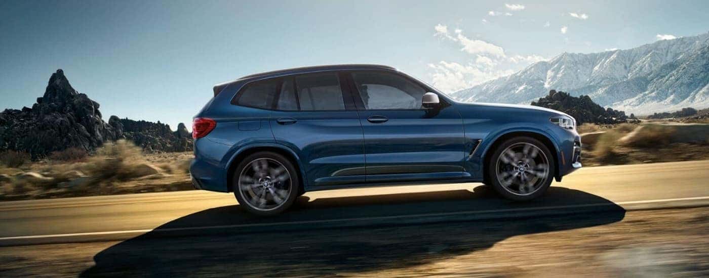 Blue 2018 BMW X3 driving up a mountain