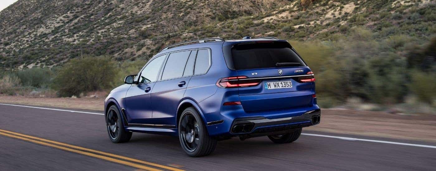 A blue 2024 BMW X7 from the rear.