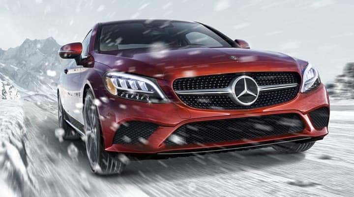 Red Mercedes-Benz sedan driving through snow