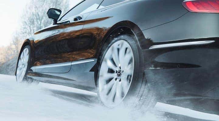 Black Mercedes-Benz sedan driving through snow