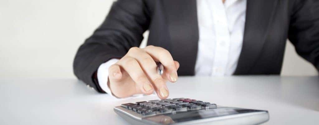 woman typing on calculator