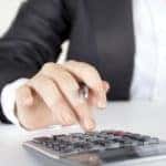 woman typing on calculator