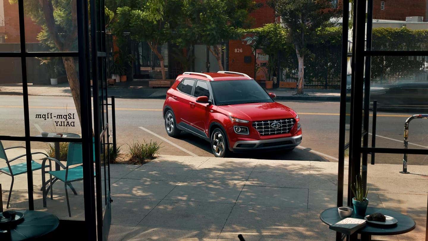 a red small suv parked in a parking space
