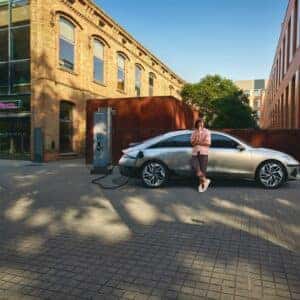 man eating ice cream leaning on right side of car