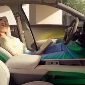 woman reading a book siiting in the front seat of a car