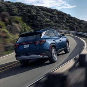 blue suv driving on a curved ascending road