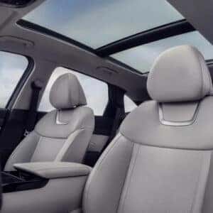 the front interior showing the sun roof and front seats of an suv