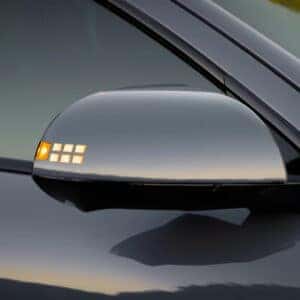 A close-up of the Hyundai Ioniq 6's side mirror featuring pixel-style LED turn signals.