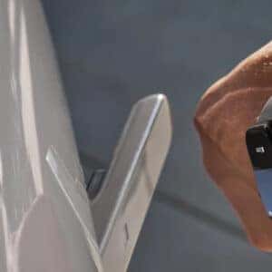 A person using a smartwatch to unlock a Hyundai IONIQ 6 via the digital key feature, with the door handle extending.