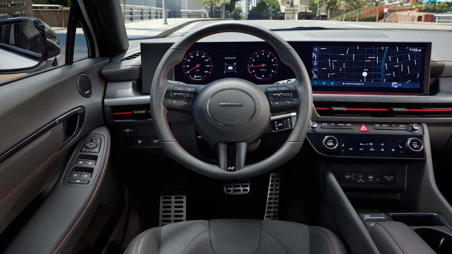 Driver’s perspective of the 2024 Hyundai Sonata N Line interior, highlighting the digital cockpit and sporty steering wheel.