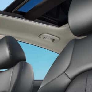 A shot highlighting the black leather front seats and open sunroof, letting in natural light inside the 2024 Hyundai Sonata Hybrid.