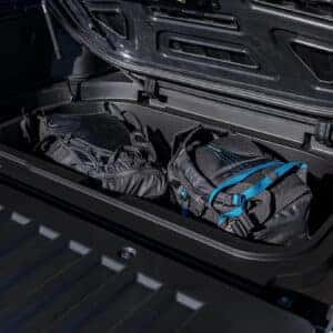 the in bed storage area of a 2025 hyundai santa cruz with back packs in it