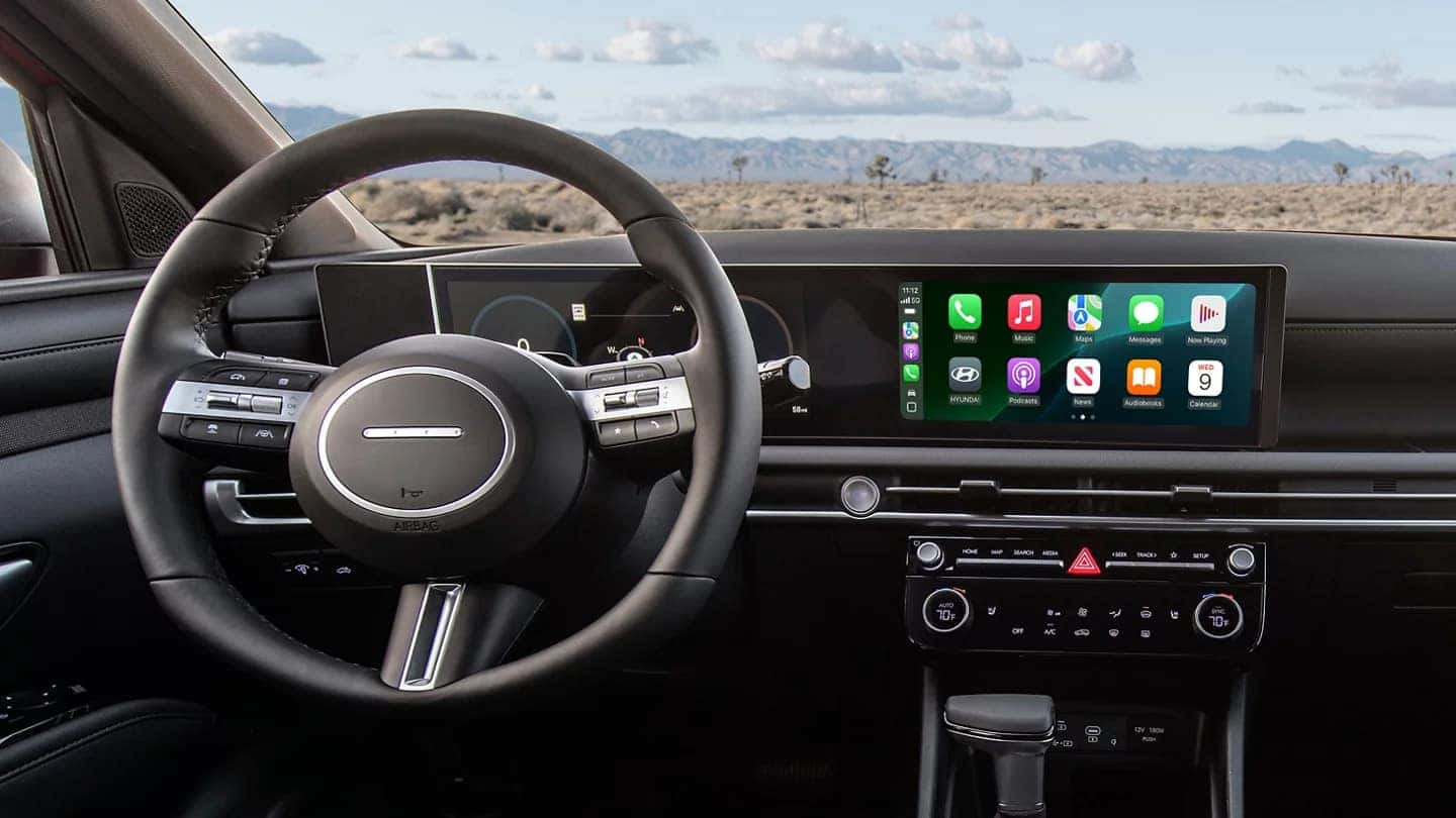 the drivers view of the infotainment system and digital cluster display in a 2025 hyundai santa cruz with a desert background out the windshield