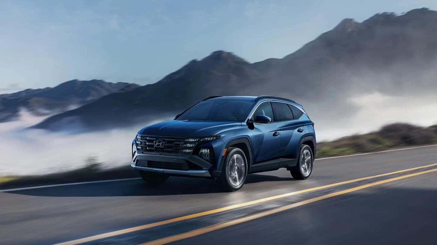 2025 Hyundai Tucson in motion on a mountain road, highlighting its aerodynamic design and smooth handling.