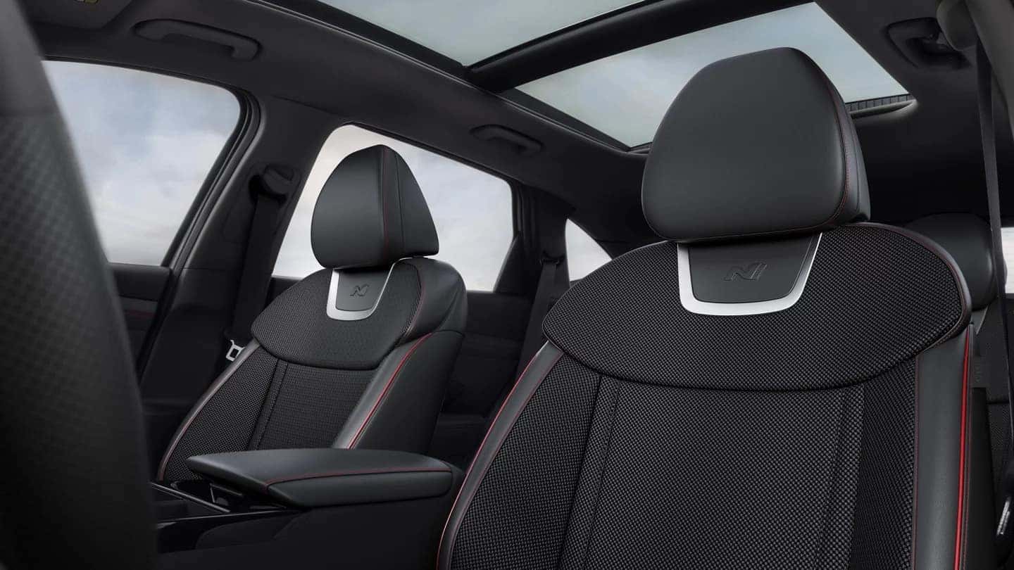 Close-up of the panoramic sunroof in the 2025 Hyundai Tucson, showcasing the N Line sport seats with black upholstery and red contrast stitching.