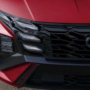 Close-up of the 2025 Hyundai Tucson N Line's front grille and headlight assembly, showing the parametric design elements and N Line badging.