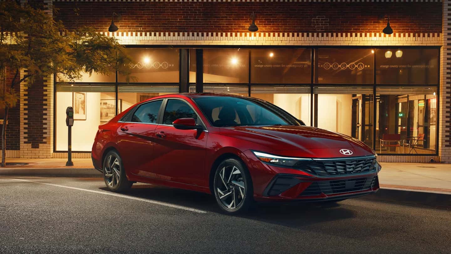 a red hyunda elantra parked at a building at night