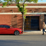2024 Hyundai Elantra Limited with the Ultimate Red Exterior parked in front a brick building