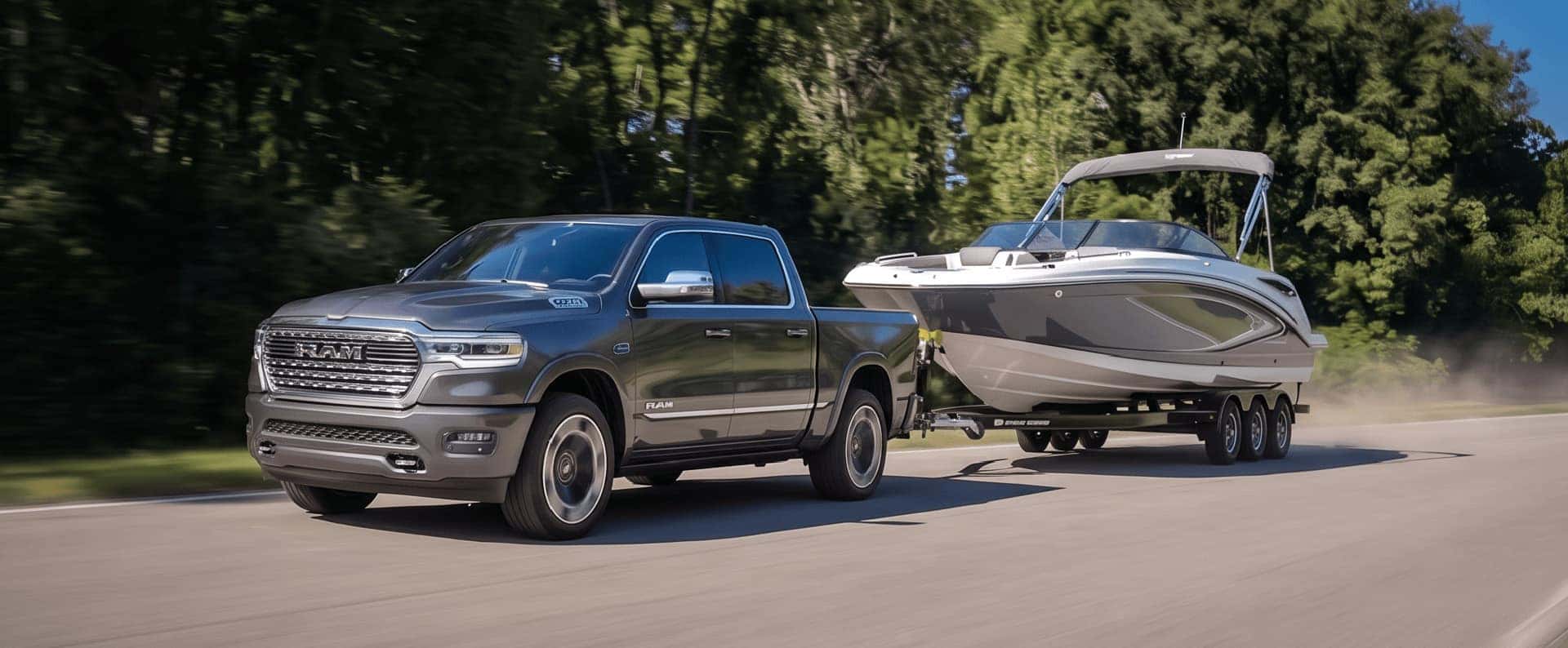 Ram 1500 towing a boat on a paved road