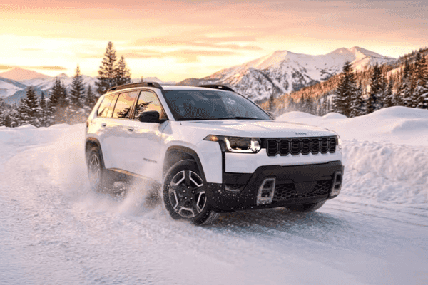 white grand cherokee on snowy mountain road