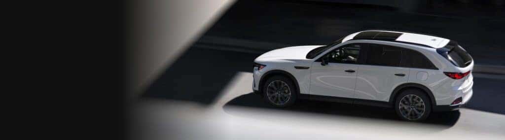 White Mazda CX-70 driving down a road